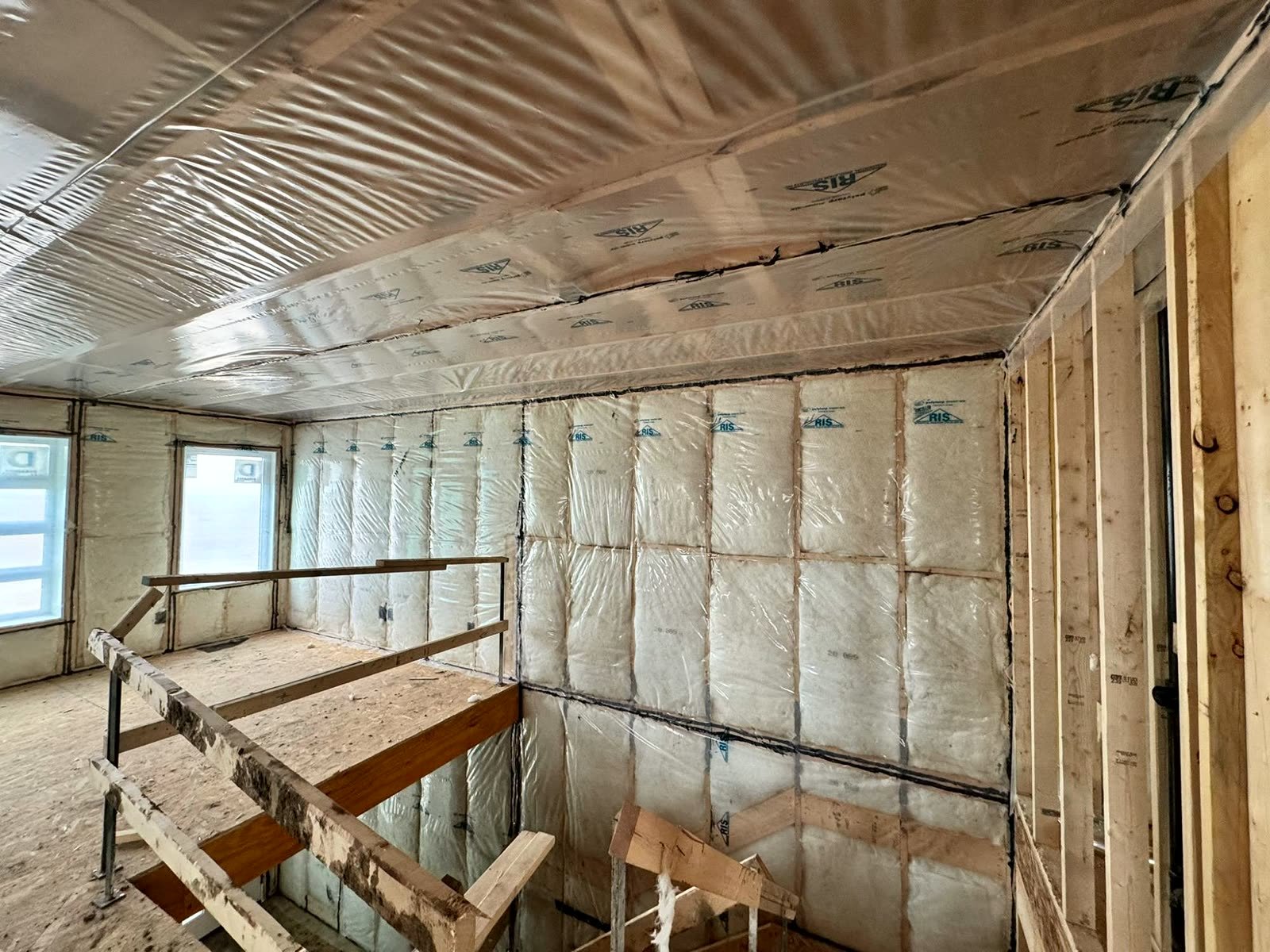 Second floor of a new home with insulation and poly on walls and ceiling