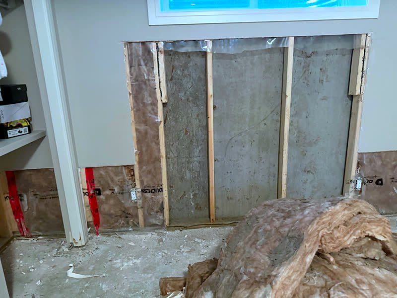Damaged insulation removed down to the concrete wall